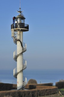 Worker wearing safety harness doing maintenance work on the Alprech lighthouse with spiralling exterior staircase near Le Portel