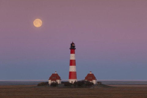 Lighthouse Westerheversand at sunset with full moon at Westerhever