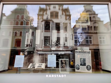 View into the shop window with reflections of gabled houses