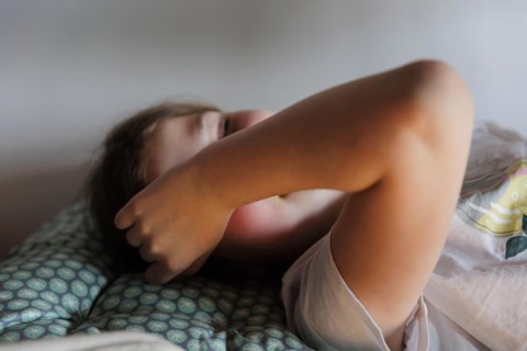 Child lying on the bed daydreaming