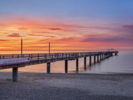 Pier on the beach of the Baltic Sea at sunset