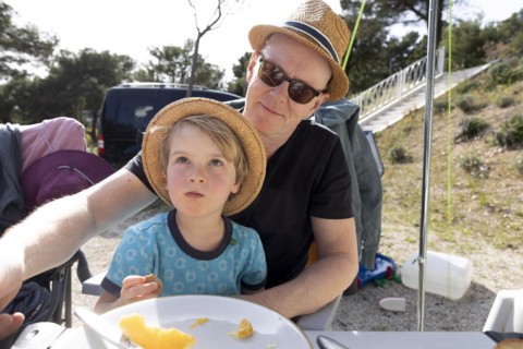 Subject: Holiday. Grandfather and grandchild sitting at the table at a campsite in Croatia