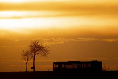 A public bus stands out in the dusk near Gebelzig