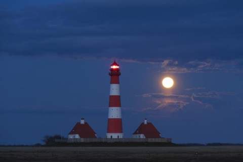 Lighthouse Westerheversand at night with full moon at Westerhever