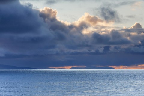 Low-lying rain clouds drift over the Summer Isles and the open waters of the blue Atlantic
