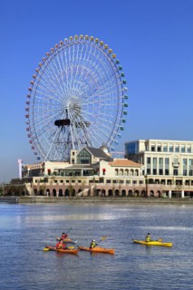 Group of kayaks on excursion and Ferris Wheel Cosmo Clock 21 of Yokohama Cosmo World in background Yokohama city Kanagawa Japan