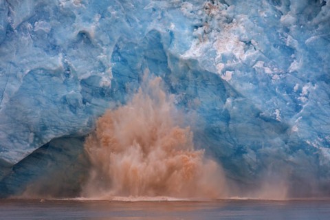 Huge ice chunk breaking from the edge of the Kongsbreen glacier calving into Kongsfjorden