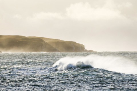 Atmospheric coastal landscape with Summer Isles at sunrise with stormy waves on open sea