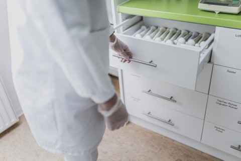An employee opens a drawer with pistols in the prescription