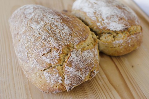 Symbolic photo on the subject of wheat bread. Freshly baked wheat bread lies on a board. Berlin