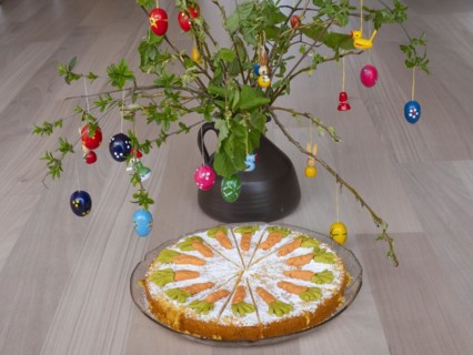 Homemade carrot cake in front of a shrub with Easter decorations