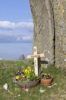 Wooden cross with flower bowls in memory of a victim of a traffic accident on a tree