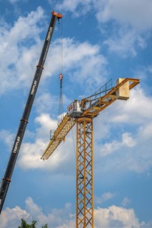 A construction crane is erected with a truck-mounted crane