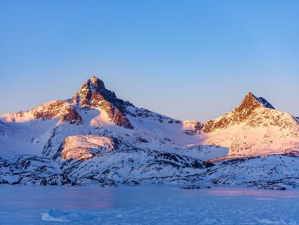 Snowy mountains above the frozen Kong Oscar Fjord