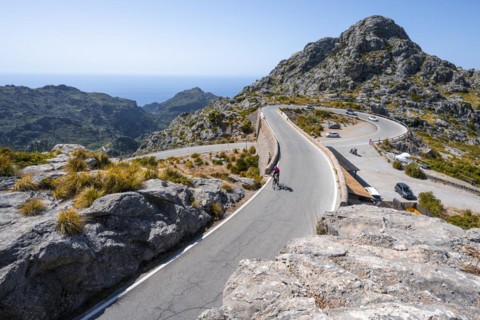 Road cyclists at the mountain pass with serpentines to Sa Colobra