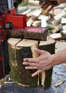 Worker making firewood with a log splitter