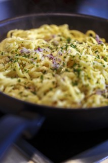 Swabian Kaesspaetzle with onions and herbs stew in a pan