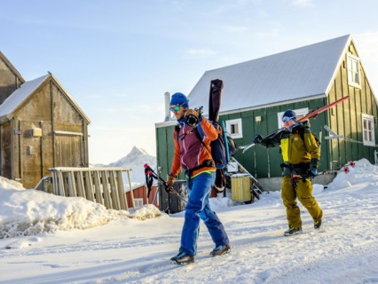 Ski mountaineers carry their skis through Tasiilaq in winter