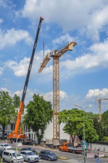 A construction crane is erected with a truck-mounted crane