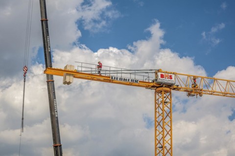 A construction crane is erected with a truck-mounted crane