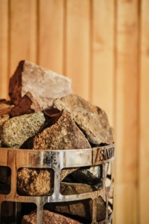 Closeup view of rocks and stones in cage in sauna heater