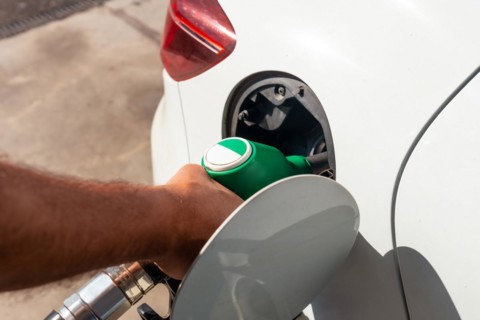 Close-up of a hand with the gun refueling gasoline or diesel fuel in a white car. Concept of transportation