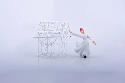 Sufi dervish and a little metal house on a white background
