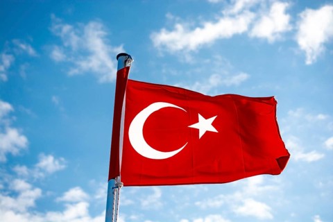 Red Turkish flag on pole on a cloudy sky