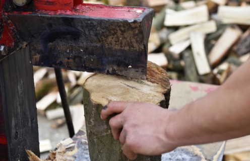 Worker making firewood with a log splitter