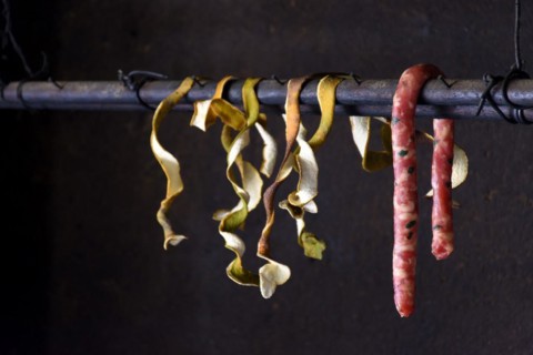 Raw sausage and orange coats hanging in the interior of popular cuisine in Brazil
