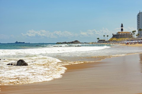 Barra beach buildings and lighthouse seen from afar with the summer sun of Salvador in Bahia