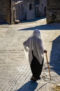 Old lady wearing the clothes and Islam veil walking the streets of Goreme in Cappadocia