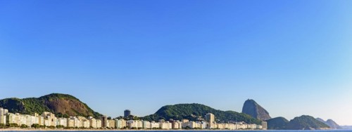 Panoramic image of Copacabana Beach and Sugar Loaf Mountain with its buildings and hills seen with the sea
