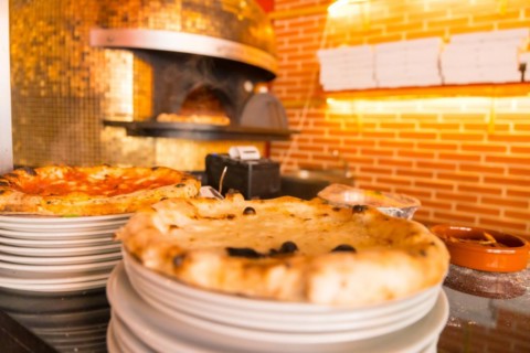 Artisan pizza oven. Freshly made pizza coming out of the oven