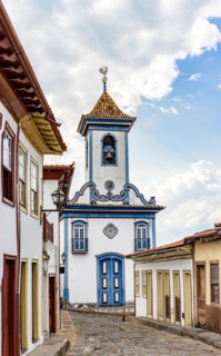 Street with cobblestones and colonial-style houses with a historic church in the background in the famous city of Diamantina in Minas Gerais