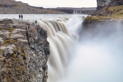 People in front of falling masses of water