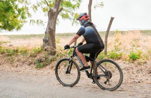 Chubby cyclist on the road. Professional cyclist on a dirt road