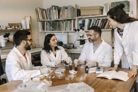 Biologists and scientists studying and researching in chemistry lab