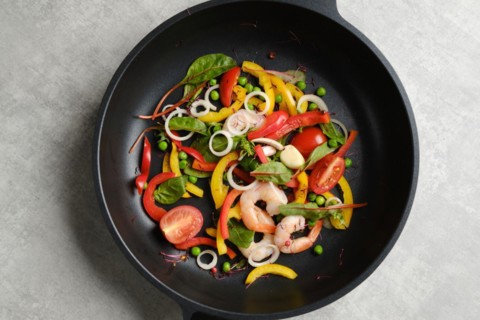 Top view of fresh vegetables and shrimps in a frying pan