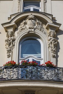 Balcony window framed with baroque figures
