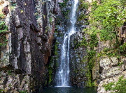 Beautiful waterfall of Veu da Noiva between the covered stones of moss and the vegetation located in an area of completely preserved nature in the state of Minas Gerais