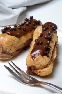 Two chocolate eclairs on a plate