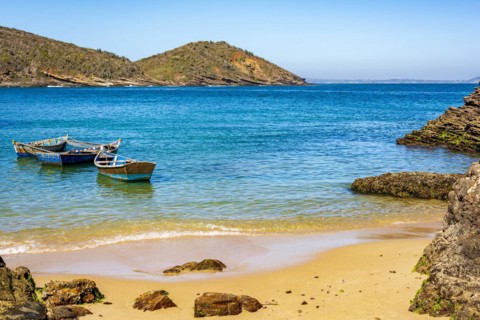 Old wooden fishing boat floating on the colorful and transparent waters of the sea of Buzios in the state of Rio de Janeiro