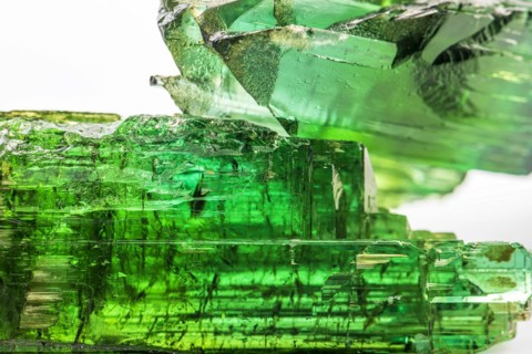 Two brazilian green tourmaline raw crystal with white background
