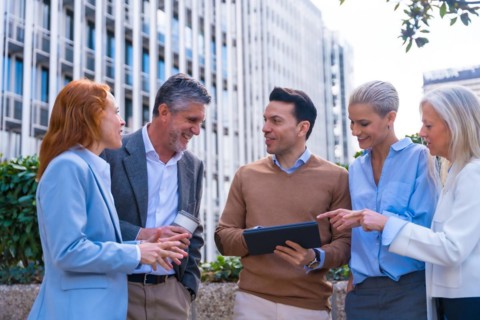 Chatting and seeing work stuff on a tablet. Group executives or businessmen and businesswoman in a business area