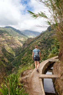 Young woman hiking along the Levada Nova hiking trail on Madeira Island