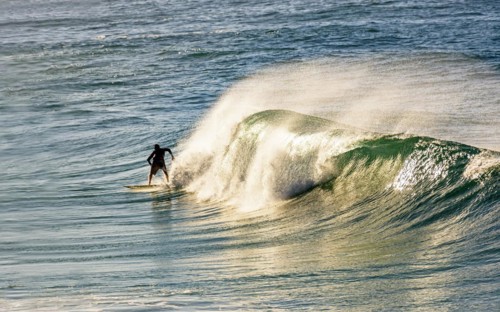 Surfer on a wave at Ipanema beach in Rio de Janeiro at dawn
