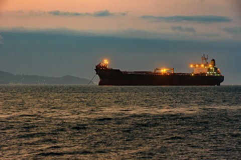 Cargo ship anchored in the waters of Ilhabela Island at dusk with the mountains in the background