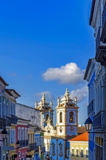 Colorful houses facades and historic church towers in baroque and colonial style with blue sky in the famous Pelourinho district of Salvador