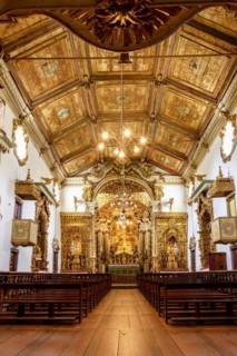 Interior and altar of a brazilian historic ancient church from the 18th century in baroque architecture with details of the walls in gold leaf in the city of Tiradentes